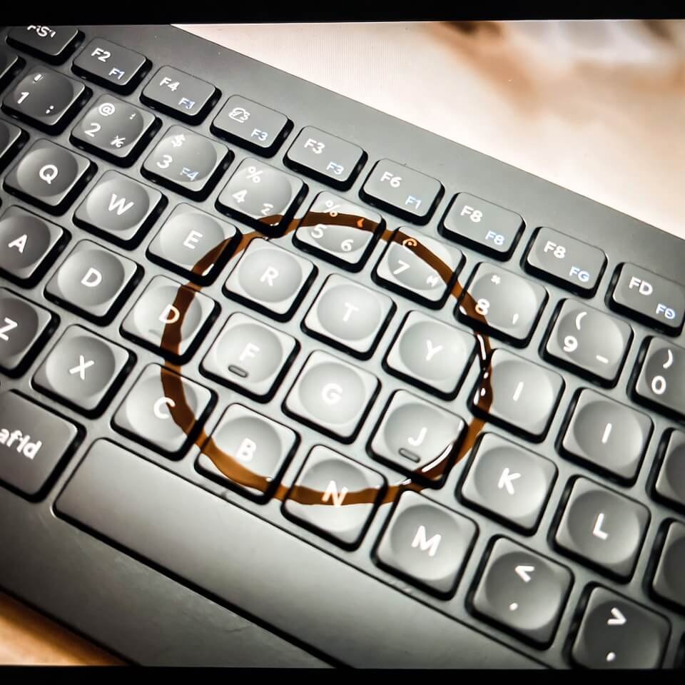 Angled phone shot of keyboard with coffee ring stain at 2 a.m.
