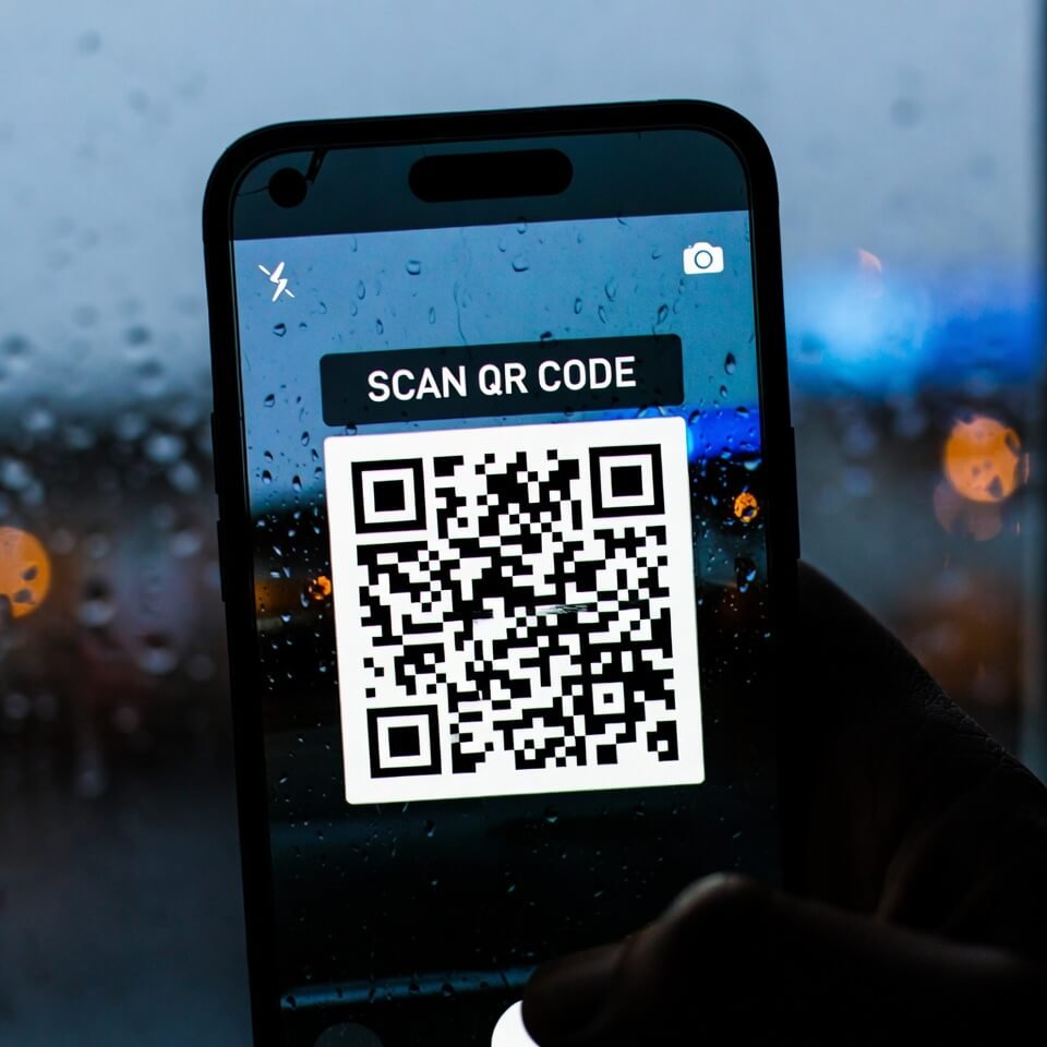 Cracked iPhone scanning warped QR on rainy motel window